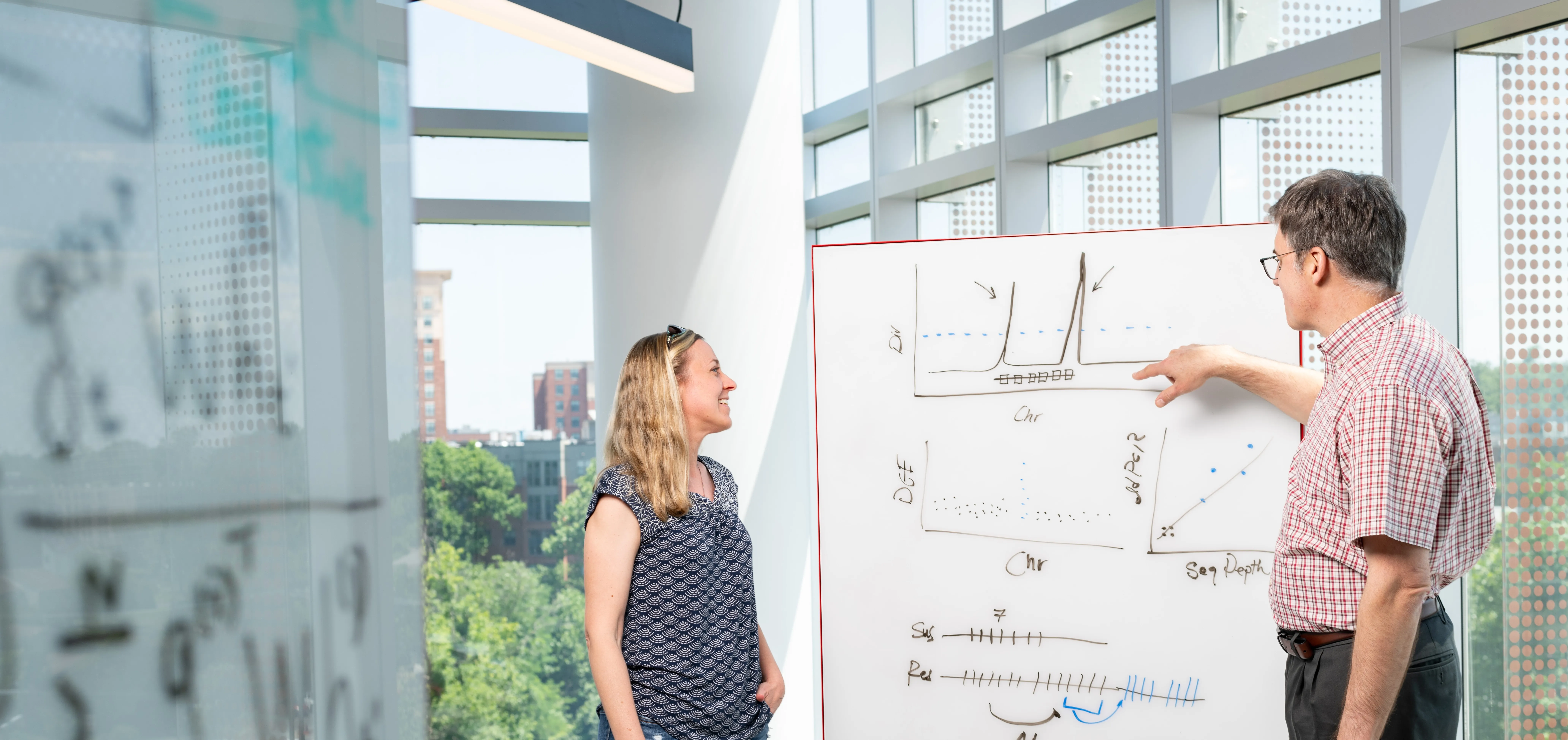 researchers talking at whiteboard